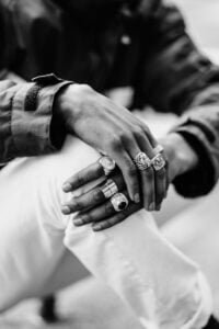 graayscale photography of man wearing rings